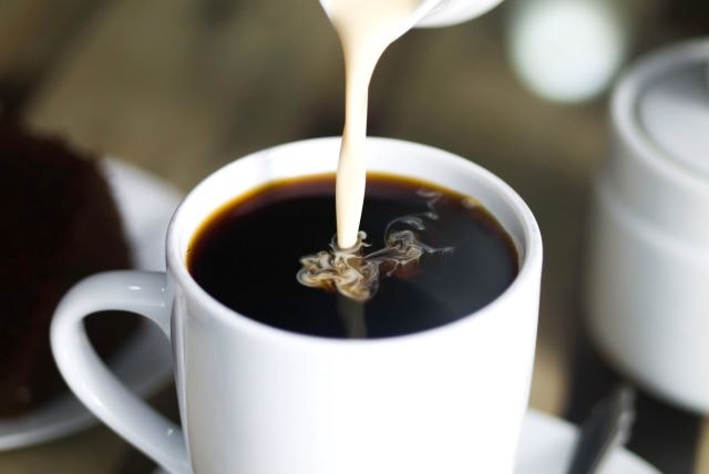 Adding milk to a cup of coffee